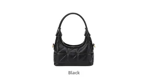 Detail of black quilted leather underarm bag with gold metal hardware and crescent shape