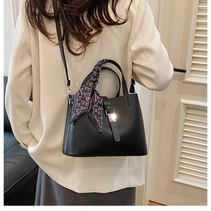Vue détaillée du sac seau en cuir noir avec boucle argentée et foulard en soie à coeurs