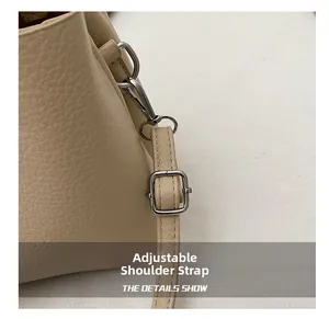 Détail de la bandoulière réglable et boucle argentée sur sac seau en cuir grainé
