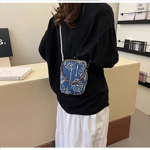 Détail du sac en jean brodé avec fermoir en métal vintage et bandoulière en perles