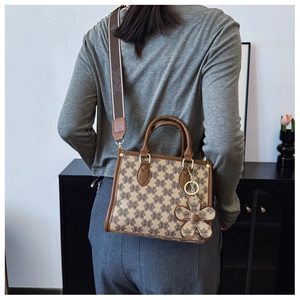 Fashionable jacquard tote bag with detachable wide strap and flower charm on model's shoulder