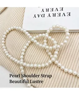 Détail d'une élégante bandoulière en perles blanches au lustre crémeux