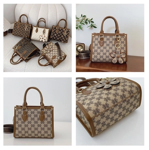 Detail of monogram tote bag with top handles, detachable strap and flower charm