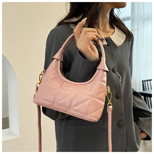 Pink quilted crescent bag with gold hardware worn with a vintage grey jacket