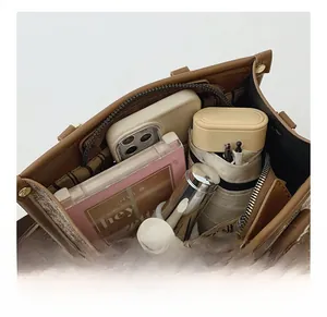 Spacious interior of the tote bag holding a phone, umbrella and cosmetics
