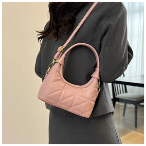 Detailed view of pink quilted handbag with gold hardware on gray blazer outfit