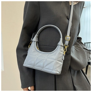 Detail of light blue quilted crossbody bag with gold hardware and adjustable strap