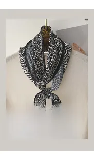 Macro detail of pleated silk scarf with black and white abstract spiral patterns