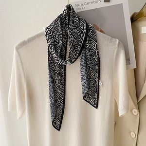 Detail of pleated silk scarf with black and white geometric maze pattern on clothing