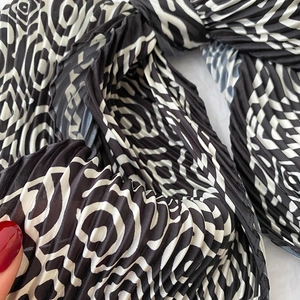 Macro shot of black and white spiral geometric plissé pleated silk scarf detail