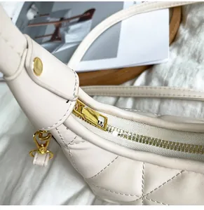 Detailed close-up of premium gold hardware and diamond quilting on cream shoulder bag