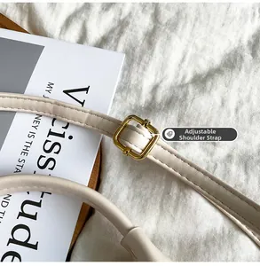 Detail of adjustable cream-white leather strap with a square gold metal buckle