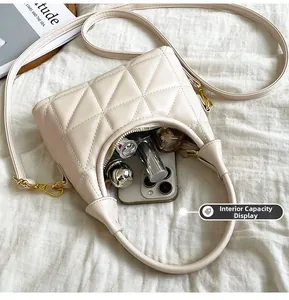 Internal view of cream quilted crossbody bag showing storage for phone and lipstick