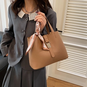 Sac seau élégant en cuir marron grainé avec foulard en soie et fermoir métallique chic