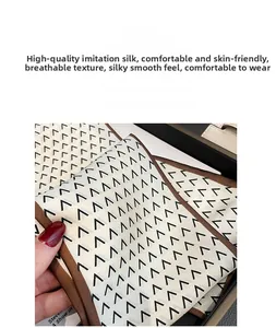 Detailed view of geometric silk-like scarf folded in a gift box showing smooth texture