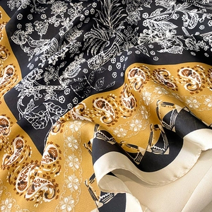Detailed macro of vintage print silk scarf with paisley and bird patterns on satin fabric