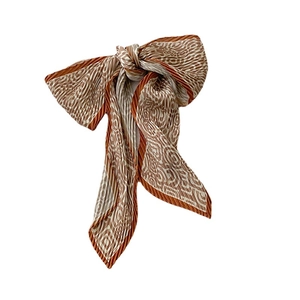 Pleated skinny silk scarf with geometric print in cream and caramel orange bow tie