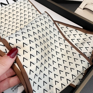 Detail shot of a faux silk long scarf with vintage geometric V-pattern and brown stitching