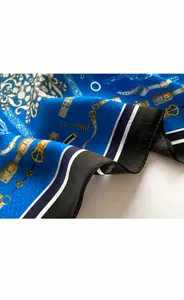 Détail macro d'un foulard en soie bleu roi avec motifs de chaînes et finitions de couture