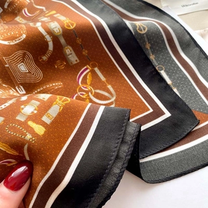 Détail d'un foulard en soie avec motifs de chaînes équestres et texture satinée