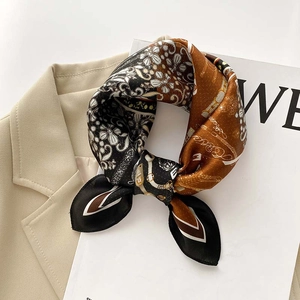 Gros plan d'un foulard en soie vintage avec motifs de chaînes fleuries sur un blazer