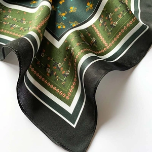 Detailed close-up of vintage floral silk scarf texture with green and black patterns