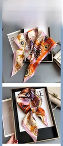 Dettaglio di un foulard in seta di gelso stampata su un vassoio con accessori moda
