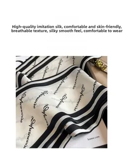 Makrodetail eines hochwertigen Kunstseidentuchs mit schwarzen Streifen und Schrift