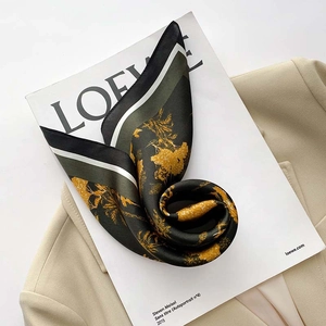 Close-up of vintage floral silk scarf with golden prints on a chic beige blazer