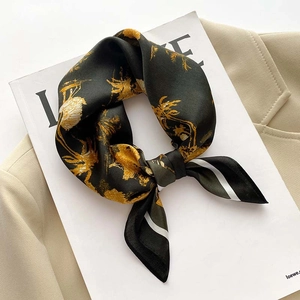 Close-up of vintage floral silk scarf with golden palm prints on a dark green fabric