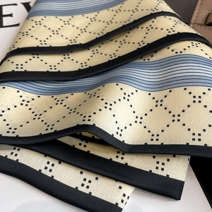 Detail eines Seidenschals mit geometrischem Rautenmuster und glatter Satin-Textur