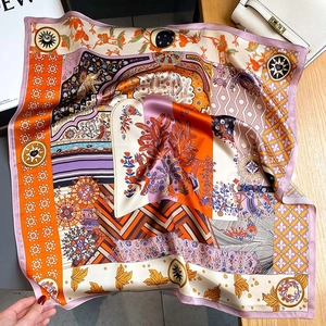 Sciarpa in seta con motivi esotici di elefanti su un tavolo in legno con accessori moda