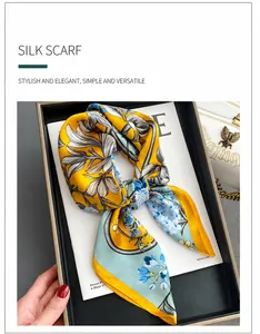 Detail of premium silk square scarf with elegant floral patterns and a silky glossy texture