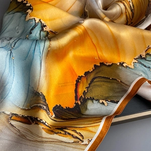 Détail macro montrant la texture marbrée fluide et brillante du tissu en soie