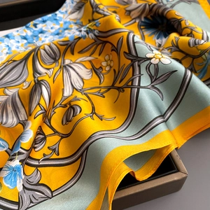 Elegant floral print mulberry silk scarf in yellow and blue with a smooth glossy finish