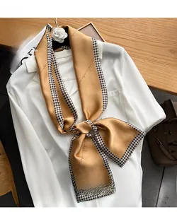 Detail of golden silk ribbon tied in a bow with houndstooth edge and vintage script