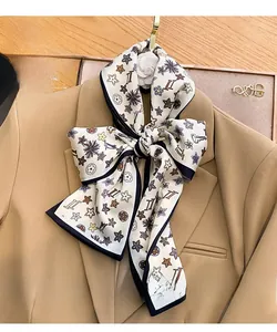 Detail of elegant printed silk scarf with floral patterns styled on a tan blazer