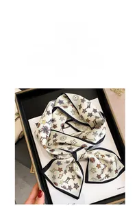 Detail of elegant silk twilly scarf with floral patterns on a luxury black display tray