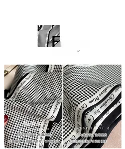 Detail of houndstooth silk scarf showing smooth texture and neat edge banding finish