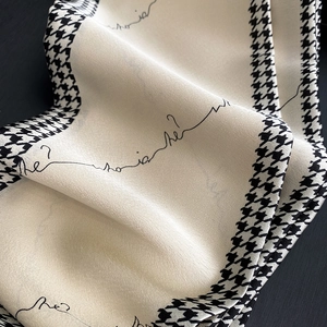Close-up of silk scarf showing glossy texture and houndstooth pattern edges