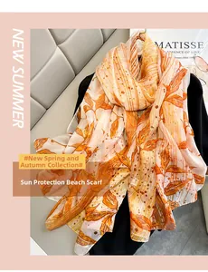 Detailed pattern of an orange floral scarf with maple leaves on a silk shawl