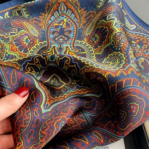 Detailed view of paisley silk scarf texture with soft folds and high-quality hemmed edges