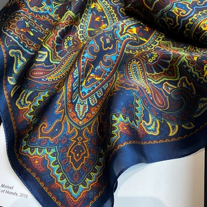Detail of silk scarf with navy blue paisley print and elegant bohemian patterns