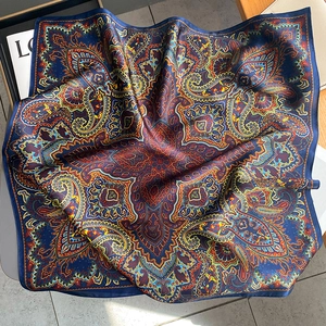 Detailed close-up of dark blue silk scarf with vintage paisley pattern and elegant texture
