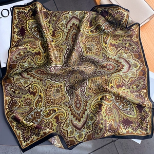Vintage paisley silk square scarf in ginger yellow and brown on wooden background