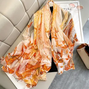 Floral print long shawl in warm orange and yellow tones with lightweight chiffon texture