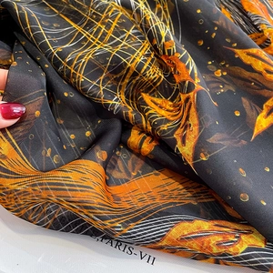 Detailed close-up showing light semi-transparent black fabric with vibrant orange leaf patterns
