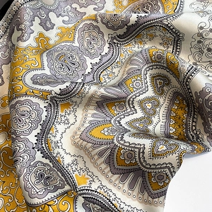 Detailansicht der weichen Seidentextur und des Paisley-Musters auf einem Seidentuch