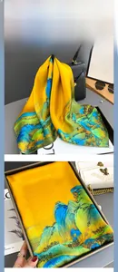 Detail of silk scarf with landscape painting hanging on bag and in gift box