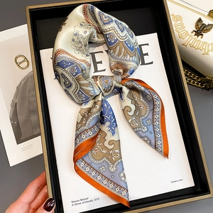 Eleganter Paisley-Seidenschal mit orangefarbenem Rand auf einem weißen Magazin